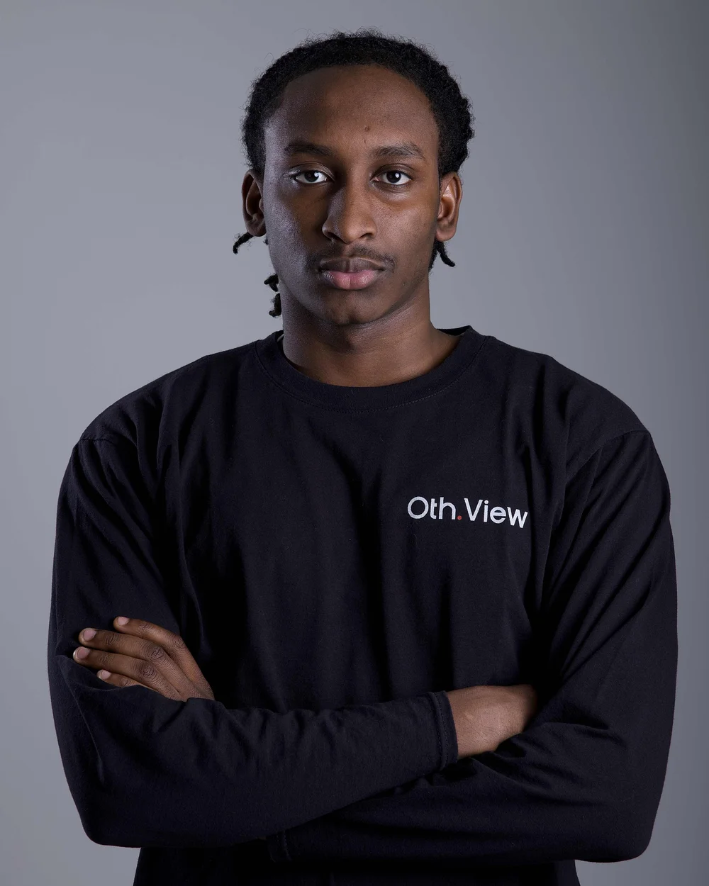 Henoch Hounga mit Twists und verschränkten Armen im schwarzen Oth.View-Shirt